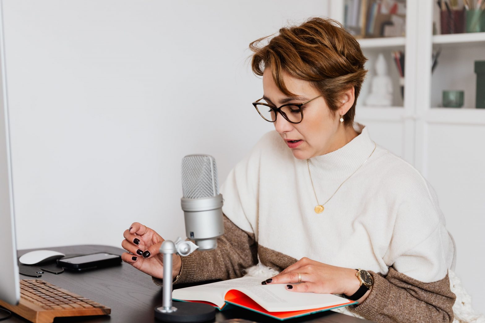 a-person-sitting-at-a-desk-with-a-microphone-min